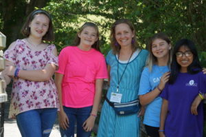 A woman and four girls standing together.